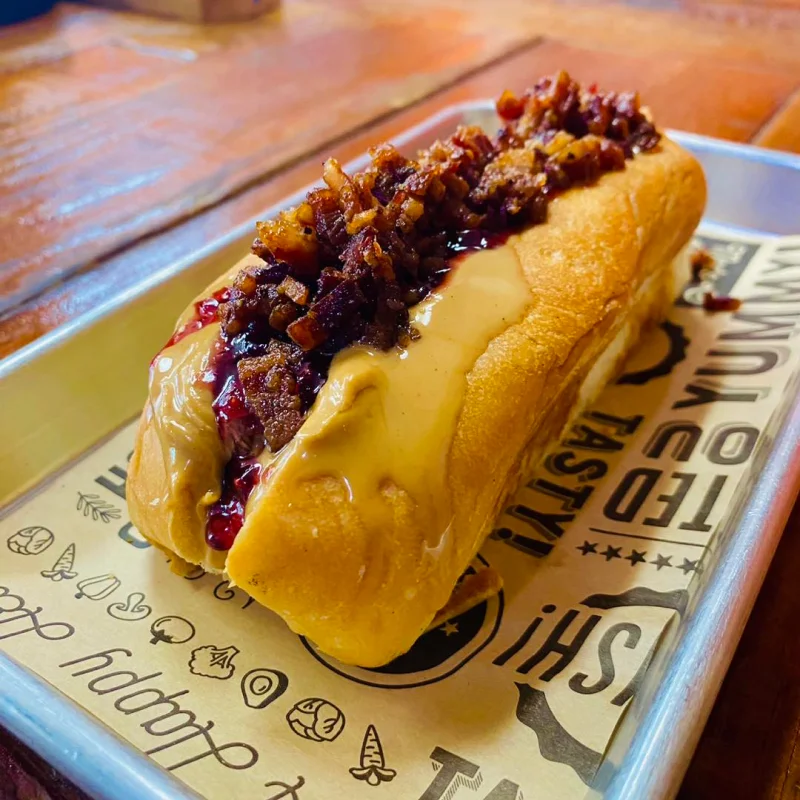 Johnny Ringo hot dog with peanut butter, bacon and raspberry jelly on a metal tray